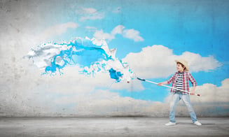 Boy of school age painting wall with brush