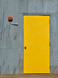 Industrial exterior yellow door with alarm bell