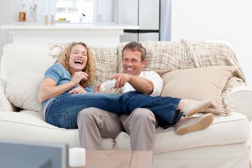 Lovers watching tv in the living room at home