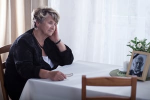 Senior woman looking at dead husband's picture