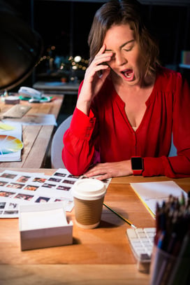 Stressed businesswoman yawning at her desk in the office