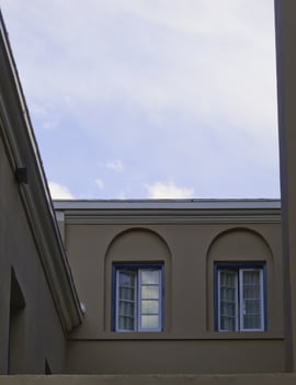 Two sets of blue-framed double windows in late afternoon