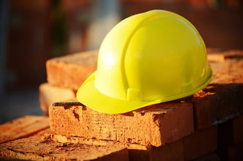 Hard hat on a brick wall.