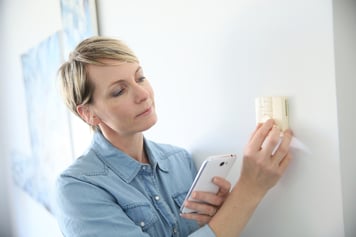 Woman porgramming indoor temperature with smartphone application-1