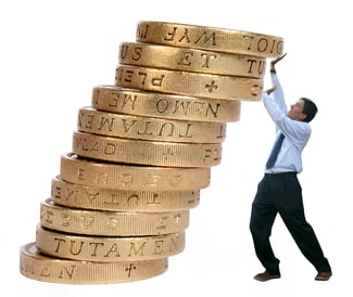 business man pushing some coins upwards to avoid them from falling down